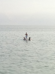 Paddle (surf boardunun daha genişi, tek kürekle çekiliyor) üzerinde 2 çocuğunu almış güzel havanın keyfini çıkaran bir bayan..